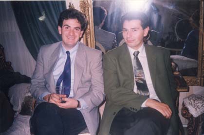 Deux hommes en costume et cravate assis devant un miroir.