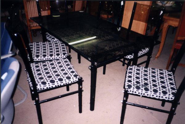 Table noire et cinq chaises avec dessins géométriques noirs et blancs.