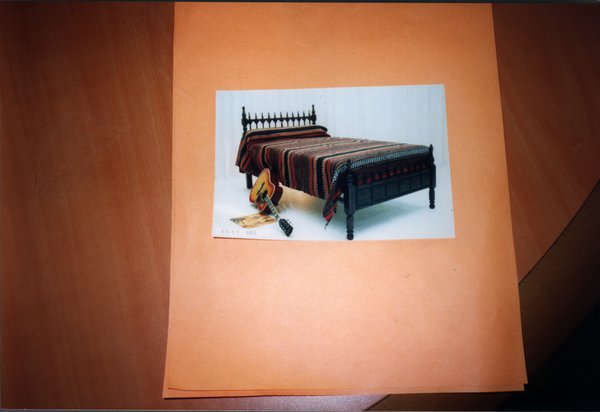 Photo de lit avec guitare collée sur une grande feuille orange.