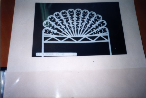 Photo de pied de lit en fer forgé blanc collée sur une feuille.
