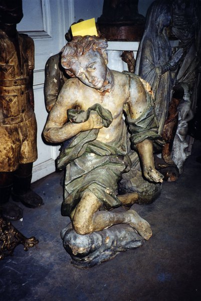 Statue en plâtre de jeune homme en génuflexion.