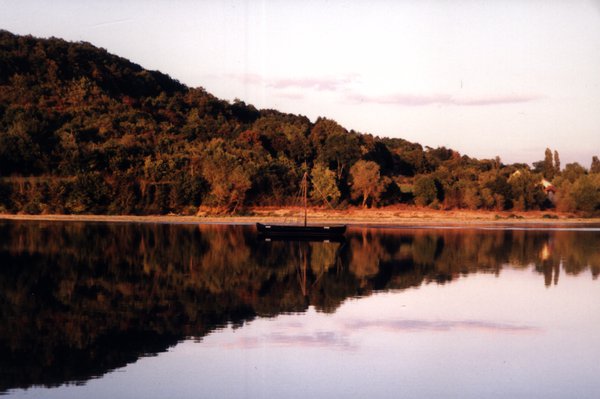Étendue d’eau avec à sa surface le reflet d’une colline.