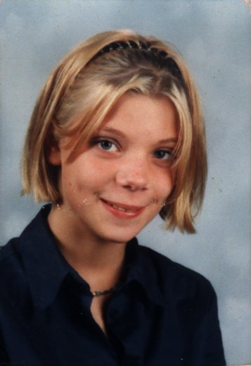 Visage de jeune fille blonde souriante.
