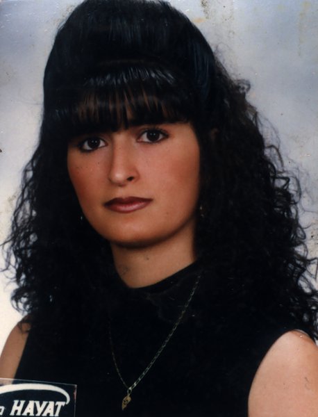 Femme à frange et cheveux bouclés noirs en tee-shirt. Image avec inscription sur la bordure extérieure.
