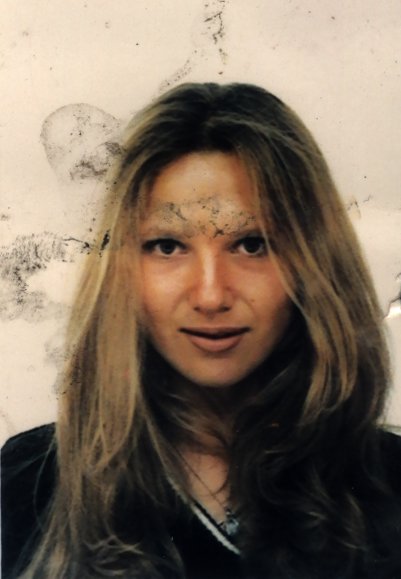 Visage de jeune femme à cheveux longs blonds. Image avec salissures.