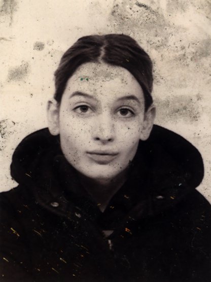 Jeune femme de face en manteau noir. Noir et blanc.
