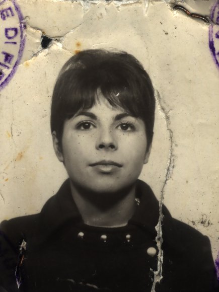 Visage de femme brune. Image avec déchirure et bord droit tamponné en bleu. Noir et blanc.