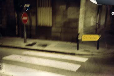 Coin de rue avec panneau de sens interdit et passage piéton.