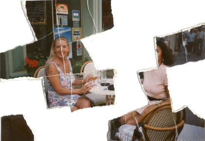 Femme blonde et femme brune à une table de café en terrasse devant un verre. Image avec déchirures, reconstituée en partie.