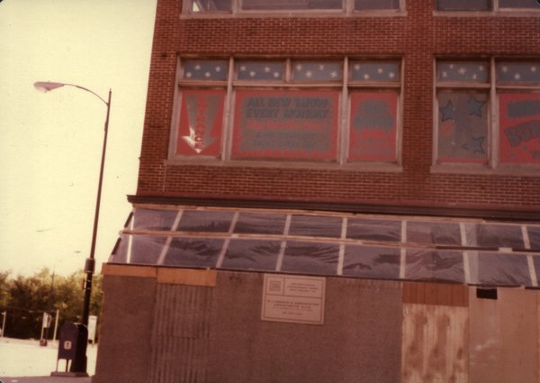 Façade d’immeuble en travaux et coin de rue avec réverbère.