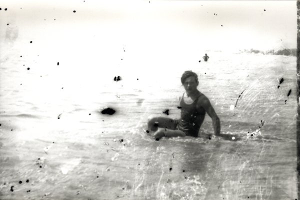 Homme assis dans l'eau de mer. Noir et blanc.ᴬᴵ