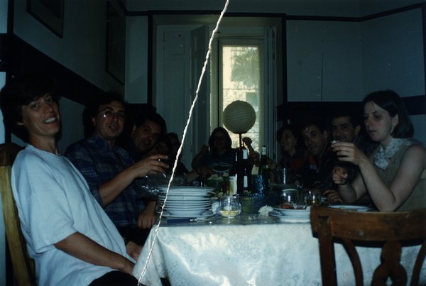 Repas entre convives autour d'une table avec lampion. Image avec déchirure, reconstituée.ᴬᴵ