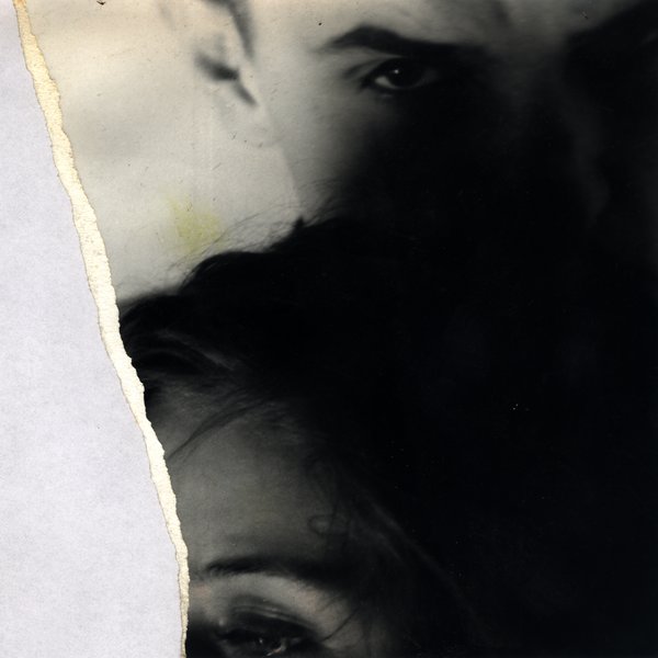 Gros plan de deux visages rapprochés dans la pénombre. Fragment déchiré.ᴬᴵ