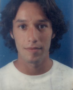Visage de jeune homme brun avec sweat blanc.