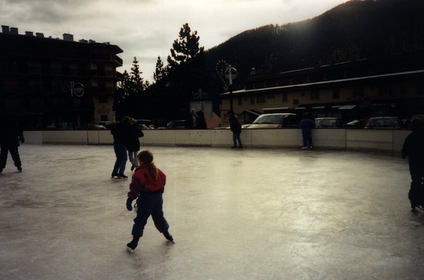 Patinoires avec un enfant en anorak et adultes sur des des patins.
