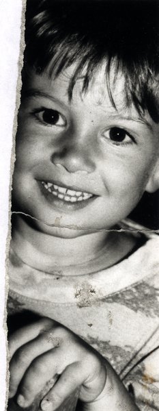 Gros plan du visage souriant d'un enfant. Fragment déchiré. Noir et blanc.ᴬᴵ