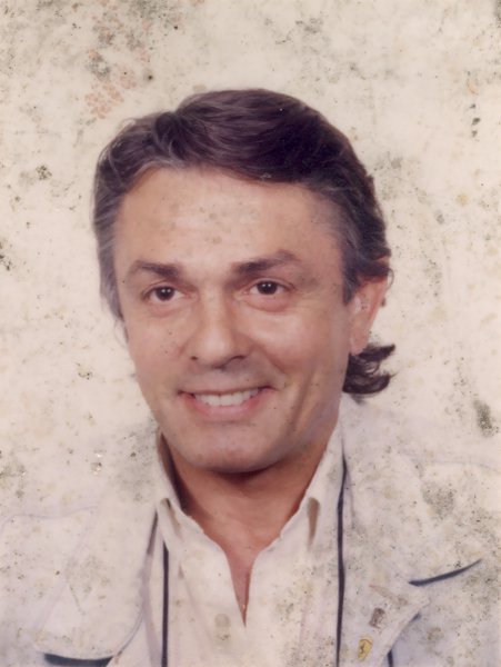 Visage souriant d’homme brun.