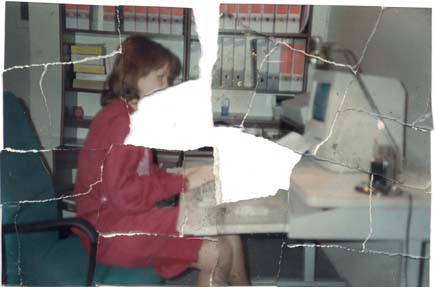 Jeune femme de profil en tailleur rose foncé tape sur le clavier d’un ordinateur. Image déchirée en partie reconstituée.