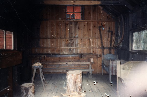 Intérieur d'un atelier en bois avec établi et outils.ᴬᴵ