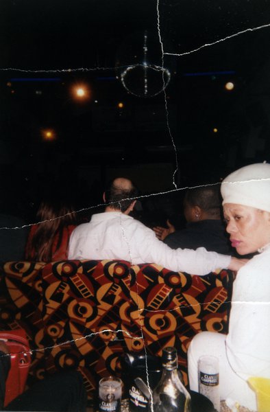 Scène de boîte de nuit avec boule à facettes et personnes assises. Image avec déchirure, reconstituée.ᴬᴵ