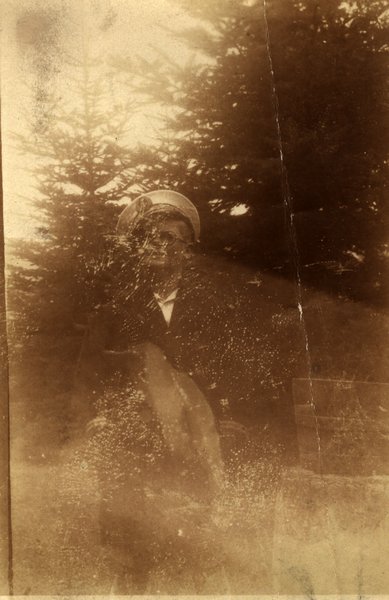 Personne en casquette parmi des sapins. Image très pâlie. Noir et blanc.ᴬᴵ