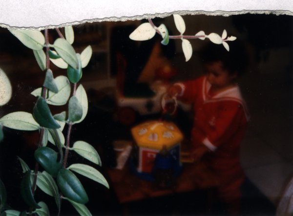 Enfant jouant avec un jouet près d'une plante d'intérieur. Fragment déchiré.ᴬᴵ