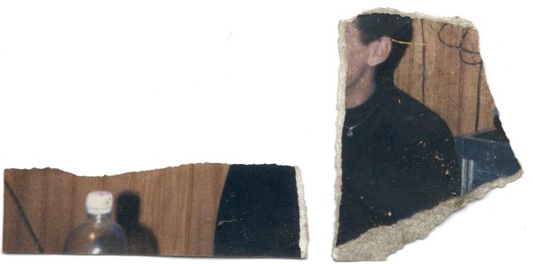 Homme brun assis et bouteille. Fragment déchiré.