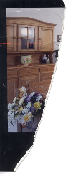 Buffet de cuisine en bois et chaise avec bouquet de fleurs. Fragment déchiré.