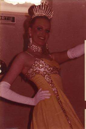 Femme souriante en longs gants blancs et robe d’apparat avec diadème et bijoux en strass. Image avec déchirure sur le bord