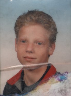 Visage de jeune garçon blond. Image avec pliure.