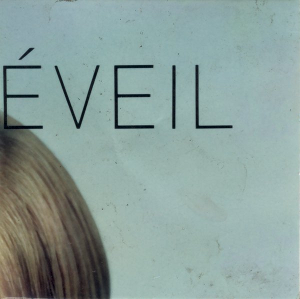 Coin de cheveux blonds et inscription en noir : « Éveil ». fragment.