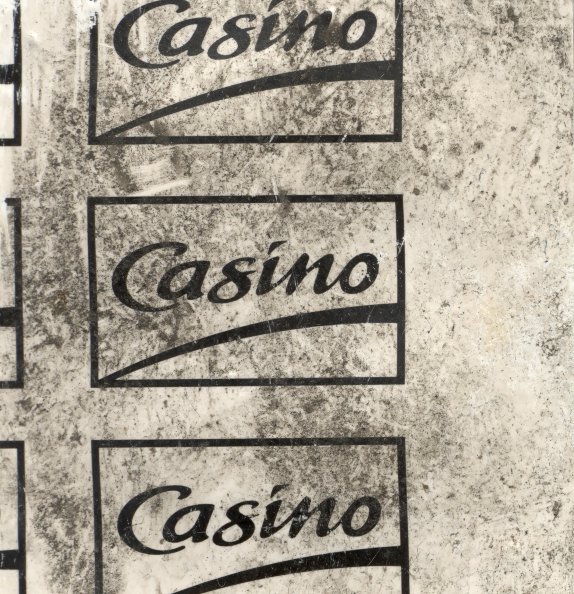 Logo du supermarché « Casino ». Image avec salissure.