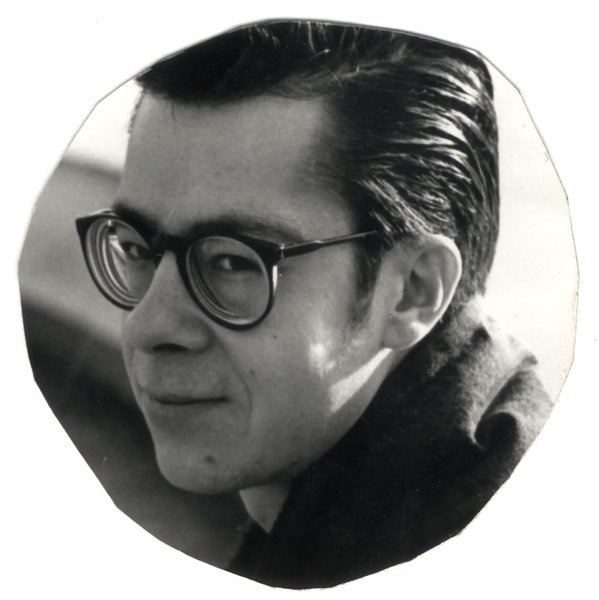 Homme brun de trois quarts cheveux gominés et  lunettes à montures noires. Image à bords découpés. Noir et blanc.