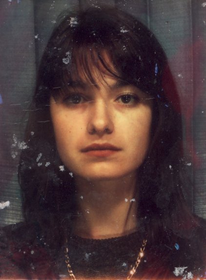 Visage de jeune fille brune à longue frange.