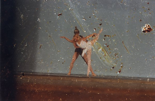 Ballerine classique en tutu blanc portée par un danseur sur la scène d’un théâtre.