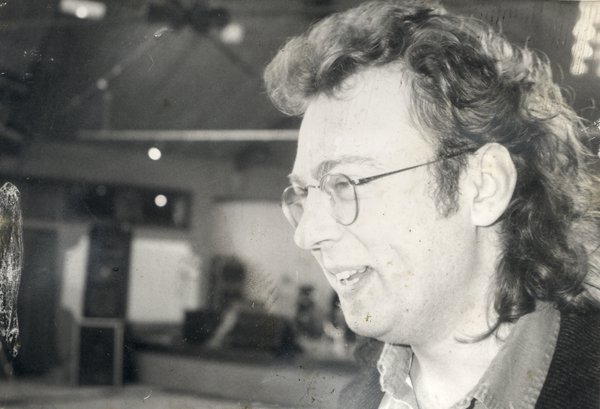Homme de profil à cheveux mi-longs et lunettes. Noir et blanc.
