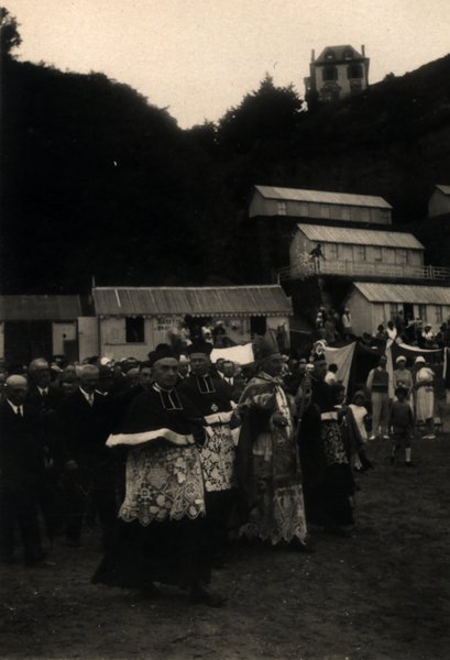 Procession religieuse avec clergé en habits d'apparat devant une foule. Noir et blanc.ᴬᴵ