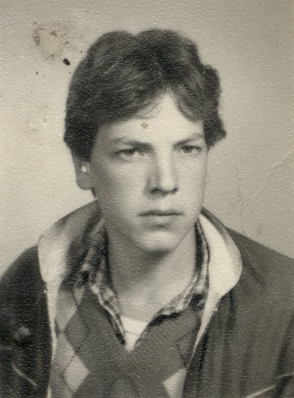 Visage de jeune homme châtain à anorak. Noir et blanc.