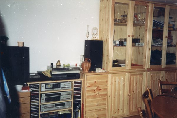 Meuble en bois clair avec vitrines, casiers, et rangements divers.