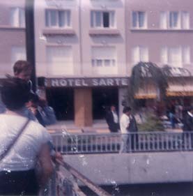 Façade d’hôtel et passants dans la rue.