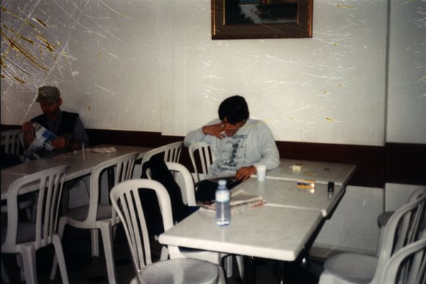 Deux hommes attablés dans un café.ᴬᴵ