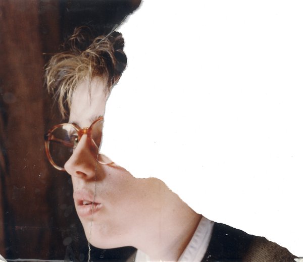 Visage de jeune femme de profil avec lunettes à grandes montures. Image déchirée.