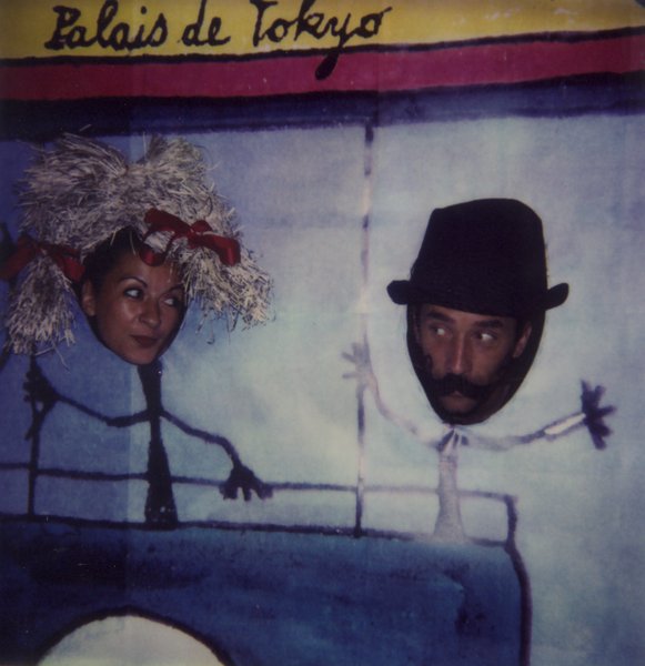 Un homme et une femme la tête sortie d’un panneau en carton titré Palais de Tokyo avec le dessin de leur silhouette.