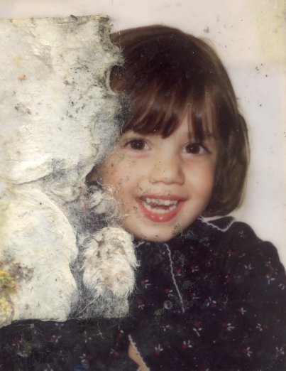 Visage d’enfant brun souriant. Image abîmée.