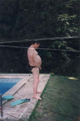 Homme barbu ventripotent en maillot de bain au bord d’une piscine en plein air. Image avec pliure.