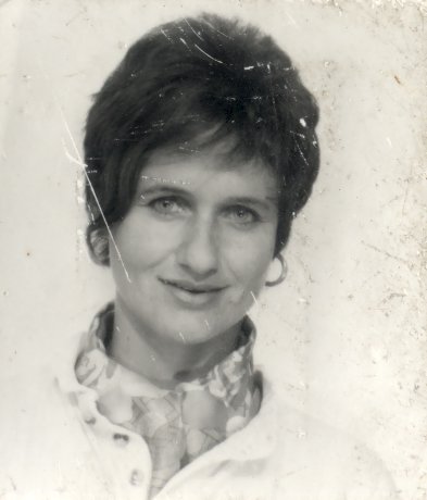 Visage de femme souriante aux cheveux courts bruns et boucles d’oreilles. Noir et blanc.