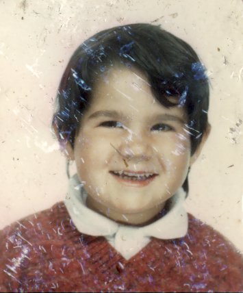 Visage de petite fille brune souriante à chemise à collerette.