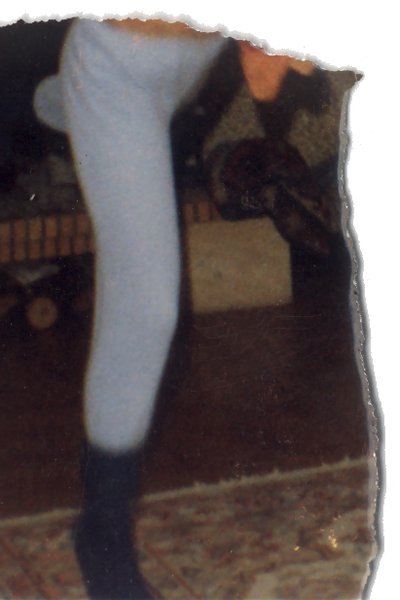 Jambe dans un pantalon fuseau clair. Fragment.