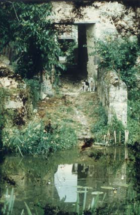 Étendue d’eau face à un passage qui débouche sur une rue en arrière-plan.