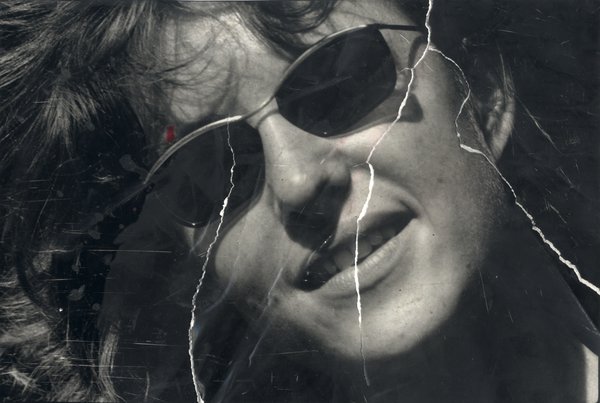 Visage de femme avec lunettes de soleil. Image avec pliures. Noir et blanc.